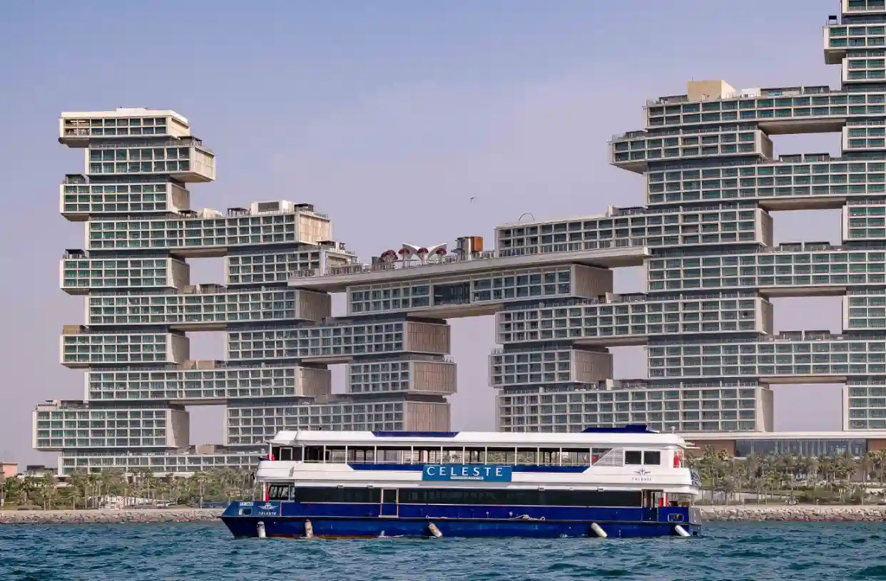 Modern yachts and dhow cruises under bright sunlight in Dubai Marina.
